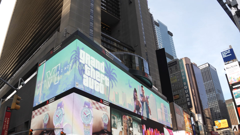 A still from the video showing a billboard with Jason and Lucia artwork.